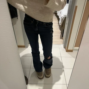 Svarta jeans med slitningar - Säljer dessa super snygga low waist bootcut jeans med hål från Gina, köpte nyligen för 499kr och gjorde hålen på egen hand men väljer nu att sälja vidare pga att jag har så många jeans. Storlek 34/s 💞 endast använda en gång. Pytte lite sydda längst ner i stora hålet men syns inte!