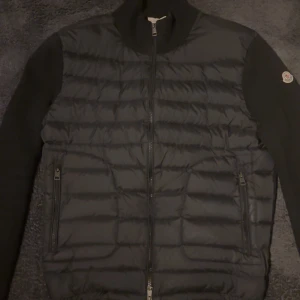 Moncler cardigan svart - Tjena! Säljer en svart Moncler cardigan då den har blivit lite för liten för mig. Haft den sen slutet av sommaren. Inte använd så ofta men har fortfarande topp kvalitet. Storleken är L men sitter som M! (42-46) DM om intresse. Pris går även att diskutera!🙏