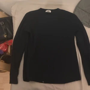 Svart långärmad tröja - Säljer en stilren svart långärmad tröja. Perfekt för kyligare dagar och enkel att matcha med olika outfits. Tröjan har en klassisk design med rund hals och normal passform.