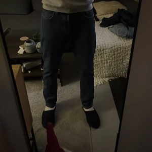 Levi's 501 jeans - Säljer ett par klassiska Levi's 501 jeans i mörkblå denim. De har en rak passform och är tillverkade i bomull. Perfekta för en avslappnad stil.