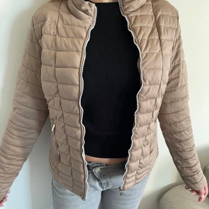 Beige vårjacka - Säljer en snygg quiltad jacka från amisu. En perfekt jacka inför våren med säkra fickor och fin färg. Stl: eu 38