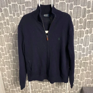 Mörkblå stickad tröja från Polo Ralph Lauren - Säljer denna feta Ralph lauren fullzipen. Inga defekter. Storlek XL men sitter mer som L. Mycket bra skick