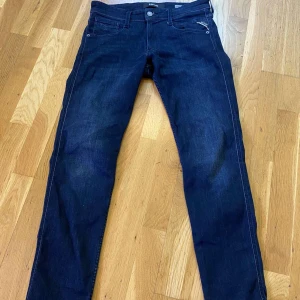 Mörkblå jeans från Replay - Snygga mörkblå Replay Anbass jeans med slim fit. Klassisk design med dragkedja och knapp. Perfekta för en stilren look.