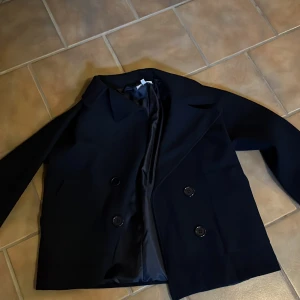 Mörklåbå  kappa med knappar från design by si - Mörkblå kappa från design by si, helt oanvänd 