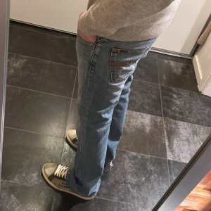 Blå jeans från Nudie -  Rak passform & snygg tvätt. 31/34. Modellen är Regular Ralf 