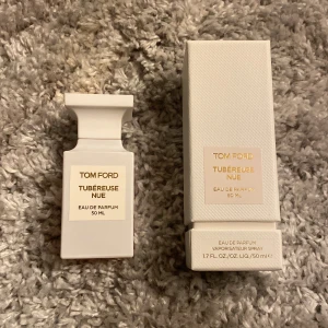 Tom Ford Tubéreuse Nue Eau de Parfum 50 ml - Tom Ford, Tubéreuse Nue, i en stilren vit flaska med guldtext. Flaskan rymmer 50 ml.  Mängd kvar ser du på andra bilden den är nästan full,  bedöm själv hur mycket som är kvar. Nypris ~ 2500 mitt pris: 800kr skriv över frågor och funderingar, priset kan diskuteras.