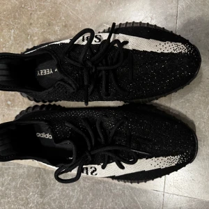 Adidas Yeezy Boost 350 V2 - Snygga Adidas Yeezy Boost 350 V2 i svart och beige med glittriga detaljer. Skorna har en bekväm Boost-sula och klassisk snörning. Perfekta för dig som vill ha stil och komfort i ett. Storlek 42. Väldigt bra skick.