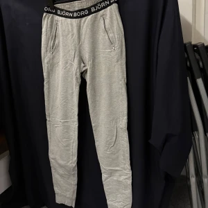 Mjukis björn borg - Snygga gråa byxor med svarta detaljer. Byxorna har en resår i midjan och två fickor på sidorna. Använd antal gånger men är i väldigt gott sick!