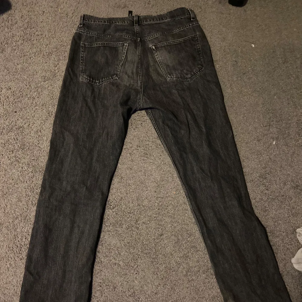 Svart/grå Weekday Jeans i storlek 30/32. Helt okej skick förutom ett litet hål långt nere vid vänster ben vilket är lätt att laga.. Jeans & Byxor.