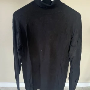 Svart polotröja från Zara - Säljer en stilren svart polotröja från Zara. Perfekt för både vardag och fest. Tröjan har långa ärmar och är gjord i ett mjukt material som känns skönt mot huden. Passar bra till höst och vinter!