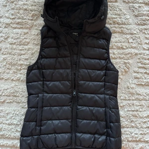 Svart dunväst från ONLY - Säljer en snygg svart dunväst från ONLY i storlek S. Västen har en dragkedja framtill och är quiltad för extra värme. Perfekt för höst och vinter! 🖤