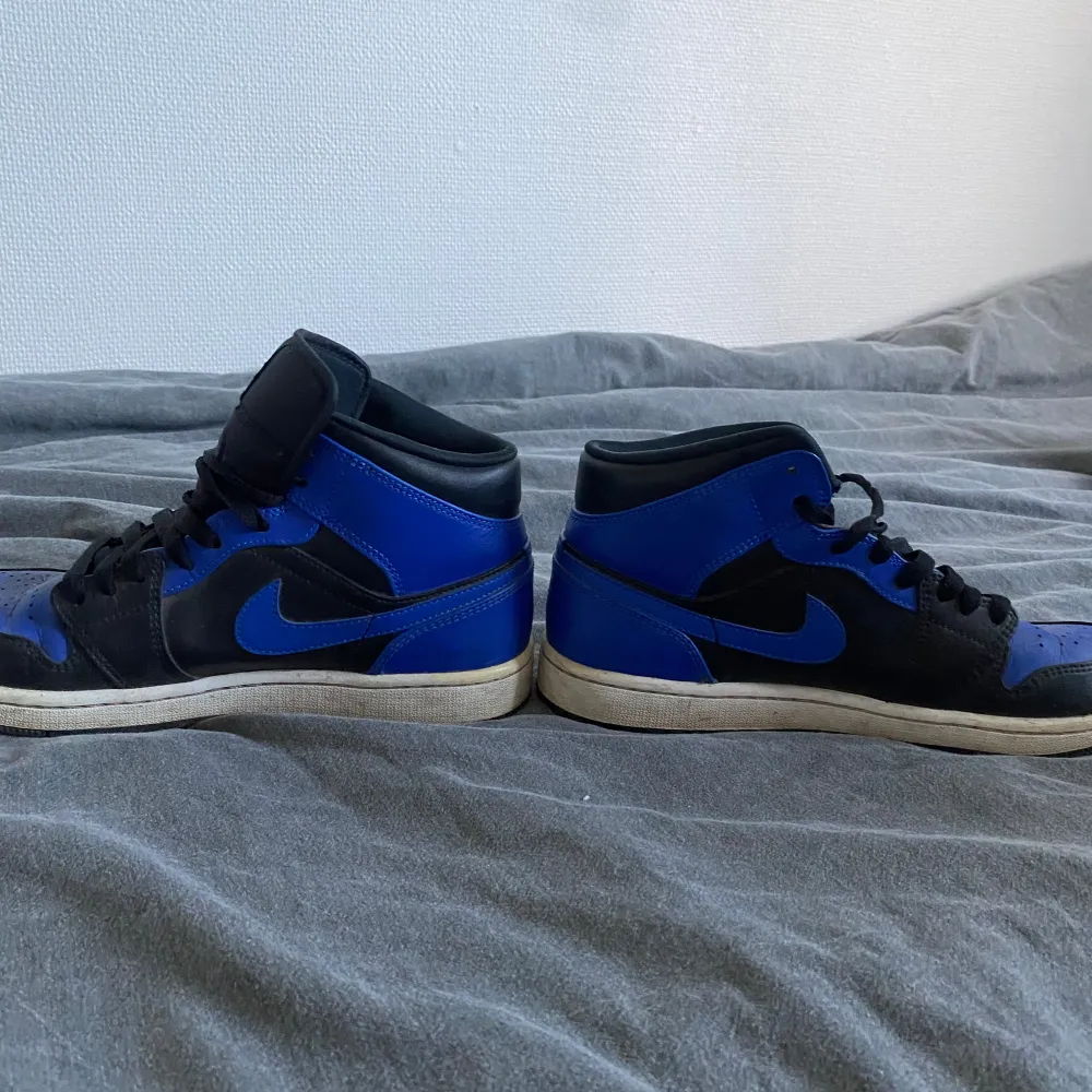 Ett par Jordan 1 mid royal blue med storlek 42 . Kengät.