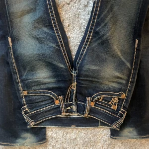 Low waist true religion jeans - Midjemått: 73cm Längd: 83cm Tecken på användning finns, se sista bilderna Storlek 25 motsvarar xs/s