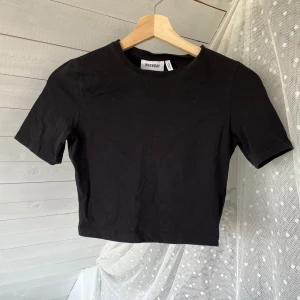 Svart croppad topp från Weekday - Storlek S och är i bra skick, sparsamt använd! Säljer då den är för liten, står s men tycker den är mer xs :)