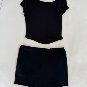 Set - Svart sett, tröjan är öppen i ryggen och kjolen har shorts inbyggt! 