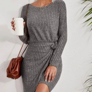 Grå ribbad klänning med knyt - Säljer en superfin grå ribbad klänning som är perfekt för höst och vinter. Den har långa ärmar och en snygg knytning i midjan som ger en smickrande passform. Klänningen är i ett mjukt och bekvämt material, aldrig använd.