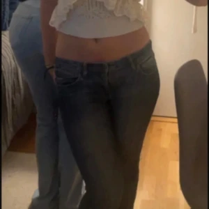 Mörkblåa vintage lågmidjade Bootcut sunshine jeans - Säljer ett par snygga blå jeans med en cool. De har en klassisk femficksdesign och knappar på bakfickorna. Perfekta för hösten!