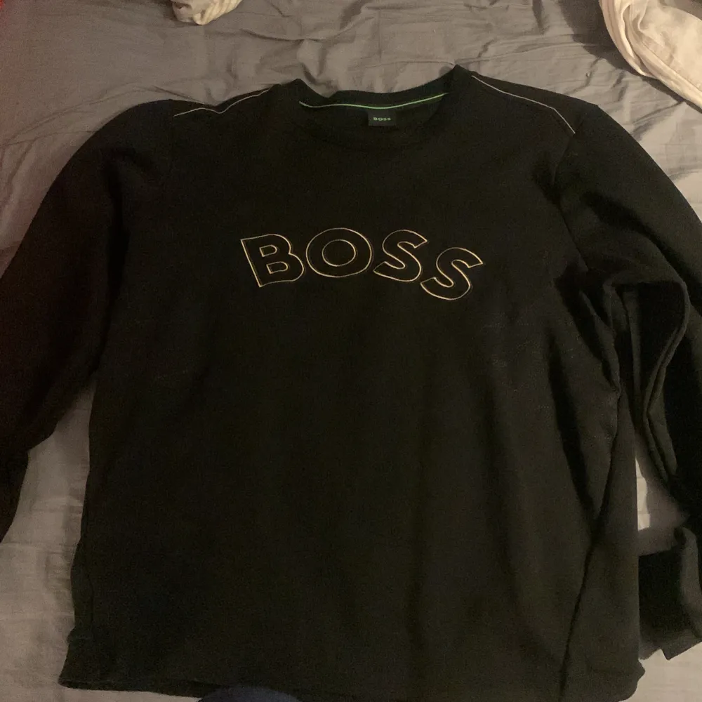 Svart/Guldig Hugo Boss tröja med storlek Large, bra skick 8/10 haft den ett par gånger, ny pris 1400. Tröjor & Koftor.