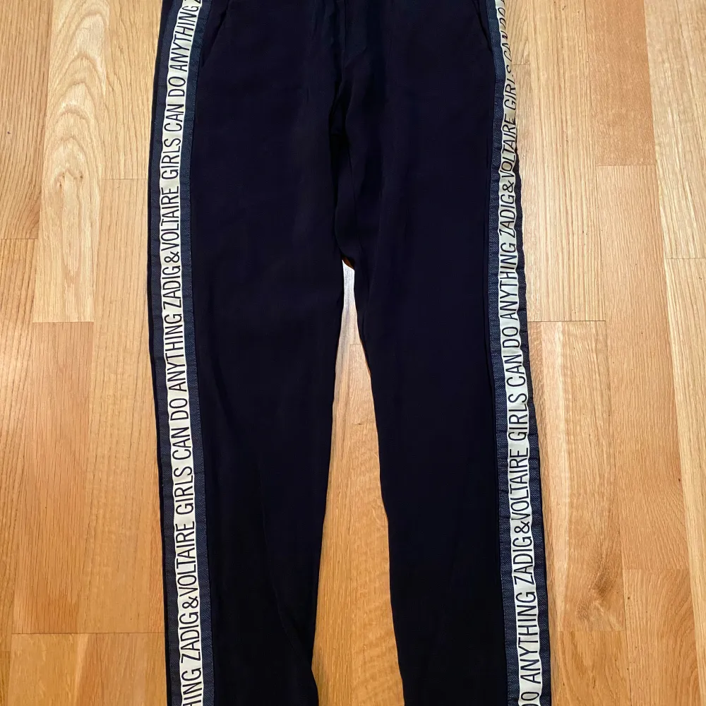 Svarta byxor med revärer i sidan i strl 36 från Zadig & Voltaire, modell Paula Band. Använda men i fint begagnat skick. Mått Midjan: ca 36 cm Längd från grenen och ner: ca 69 cm 97,5% viskos och 2,5% elastan Kommer från ett djur och rökfritt hem.. Farkut & Housut.