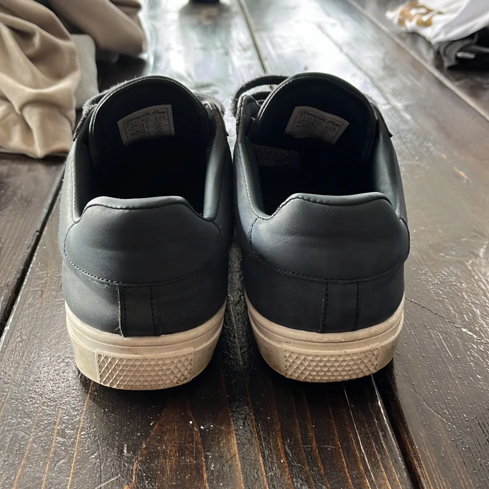 Säljer ett par navy sneakers. De har en klassisk design med snörning och en vit sula som ger en snygg kontrast. Skorna är i bra skick och perfekta för vardagsbruk. Passar till nästan alla outfits! Tvättar dem efter köp!. Skor.