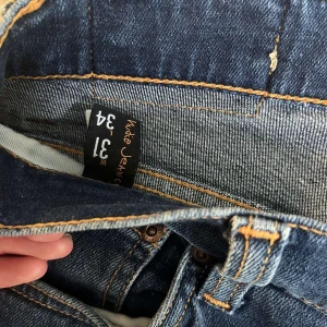 Nudie jeans mörkblåa - Sparsamt använda nudie jeans i 9/10 skick utan några defekter. Modellen på jeansen heter grim tim. Killen på bilden är 185cm och väger ca 70kg. Waist är 31och lenght är 34. Säljer pga att dem inte längre kommer till användning. 