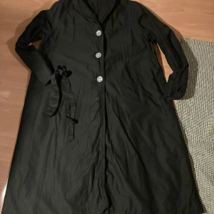 Vintage Kappa  - Tunn kappa med foder. Knappar upptill och vid modell Finns ett smalt skärp med 