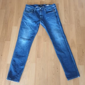 Blå jeans från Replay - Säljer ett par snygga Replay anbass slim fit i ny skick. De är använda vid tre tillfällen. De har en klassisk femficksdesign och en bekväm passform. Perfekta för både vardag och fest! Säljer dessa jeans pga att de är för stora för mig. Ny pris: 1 750
