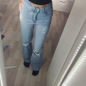 Säljer ett par ljusa jeans från Cubus i storlek XS. De är högmidjade och har en wide fit, vilket ger en skön och avslappnad look. Jeansen har coola slitningar på knäna som ger dem en trendig touch. Perfekta för både vardag och fest! 