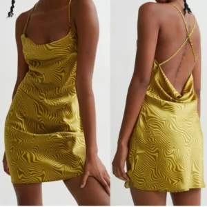 Grön festklönning - Supersöt festklänning i glansigt polyestertyg. Rygglös/ halter slip-modell Nyskick