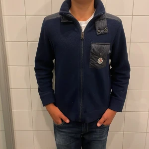 Moncler Enfant - Fint skick, Perfekt till hösten, köpt på NK, storlek 154/158, 100% Autentisk! Säljer billigt eftersom att den är väldigt gammal! Pris kan diskuteras!