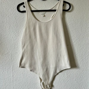 Vit ribbad bodysuit från H&M - Ribbad body från H&M. Endast använd en gång.