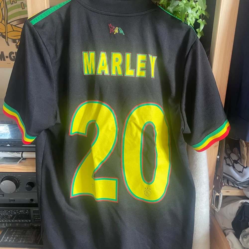 Den berömda Bob Marley inspirerade tredjetröjan från Ajax säsong 21/22.  Marley #20 på ryggen, köpt hos Ajax webbshop.  Perfekt skick, sällsynt.. T-shirts.