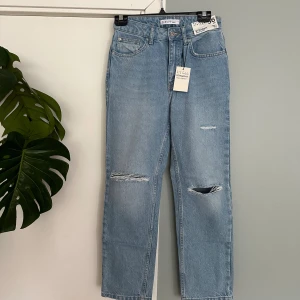 Nya vintage högmidjade jeans med slitningar - Nya vintage högmidjade jeans med slitningar. Lappar kvar. Formar fint och raka i benen.