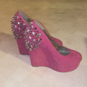 Rosa platåskor med nitar - Snygga rosa platåskor med spetsig tå och klack. Skorna har coola nitar på baksidan som ger en edgy look. Perfekta för att sticka ut på festen!