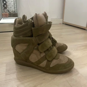 Isabel Marant skor äkta - Säljer dessa Snygga gröna skor från Isabel Marant i mocka och syntet. ÄKTA!Skorna har en unik design med flera kardborreband och en högre ankel. Perfekta för en trendig look. 