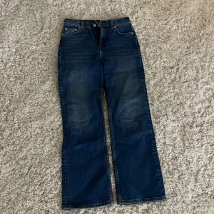 Blå jeansbyxor - Ett par  blå jeansbyxor med klassisk femficksdesign och dragkedja från Arket. Byxorna har en rak passform och är perfekta för en avslappnad stil. De har en lätt tvättad look som ger en cool touch.