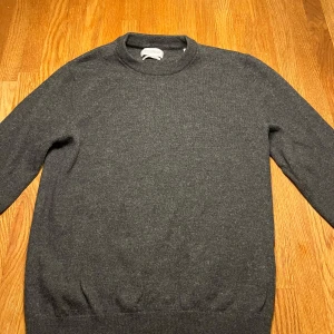 Grå merinoulltröja från These Glory Days - Säljer en stilren grå tröja i merinoull från These Glory Days. Tröjan har en klassisk design med rund hals och långa ärmar, perfekt för kyligare dagar, kom privat för mer frågor 