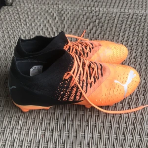 Puma future - Snygga fotbollsskor från Puma i orange och svart. Säljes pga att de är för små.