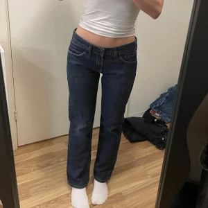 Mörkblå jeans från Crocker - Snygga mörkblå jeans från Crocker med klassisk femficksdesign. De har en rak passform och är perfekta för en avslappnad stil. Jeansen har en låg midja och är tillverkade i slitstarkt denim. Storlek 170cm men passar mig som har 25-26 i midja och är 160cm lång 