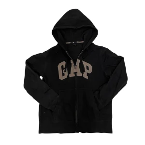 Marinblå Gap zip-up hoodie - Säljer en Marinblå hoodie från Gap med dragkedja och stor logga på framsidan. Den har en klassisk design med huva och långa ärmar. Perfekt för en avslappnad stil. Marinblå INTE svart!
