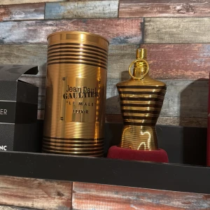 Le male elixir 20-30 ml kvar - Säljer en lyxig parfym från Jean Paul Gaultier, Le Male Elixir. Flaskan är formad som en manlig torso i glänsande guld med röda ränder. Den kommer i en elegant guldfärgad metallförpackning. Perfekt för den som vill ha en unik och stilfull doft. 20-30 ml kvar