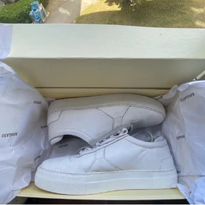  Axel Arigato - Snygga vita sneakers från Axel Arigato med en stilren design. Säljer pågrund av att jag inte haft någon användning av dem. Köpte av en person på plick för ett tag sen men som inte kommit till användning.