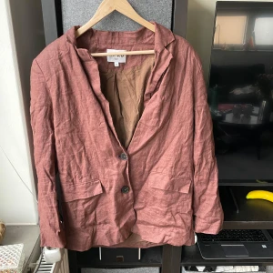 Brun kavaj från märket NAKD - Säljer en stilren brun kavaj från NAKD i storlek 36. Kavajen har en knapp framtill och knappt vid ärmen.