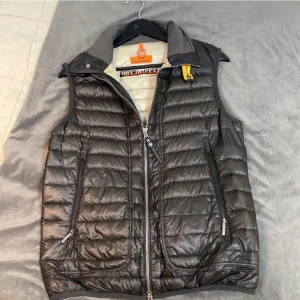Svart dunväst från Parajumpers - Snygg svart dunväst från Parajumpers med dragkedja och hög krage. Västen har en quiltad design och praktiska fickor på insidan. Perfekt för kyligare dagar. Jag köpte den från plick och den är för litet för mig. 