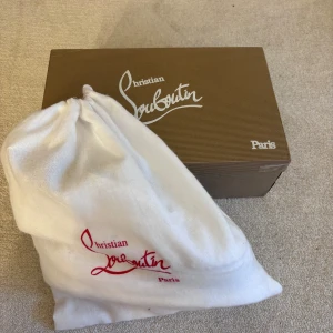 Vita sneakers med nitar från Christian Louboutin - Säljer ett par vita sneakers från Christian Louboutin med ikoniska röda sulor och nitar på tån. Skorna har snörning och är tillverkade i skinn. Perfekta för att ge en edgy touch till din stil. Säljer då jag använder mina andra mer. Osäker på om dom är äkta men fick dom i present för ett halvår sen och har använt 2 gånger. 8 extra nitar följer med🙌storlek 41 eller 42