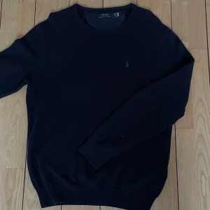 Stickad Ralph Lauren tröja  - Säljer nu denna riktning sköna stickade tröja från Ralph Lauren i Marinblå. Skick 8/10, använda ett fåtal gånger och ingen defekter! Skicka om ni har några funderingar kring tröja eller pris!
