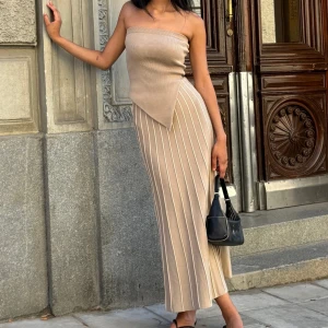 Adoore Lausanne dress - Helt ny Adoore klänning. Lausanne Bandeaue dress i beige. Aldrig använd och prislappar kvar. Skönt material som formar sig fint till kroppen. Perfekt till alla säsonger. Nypris: 1495kr