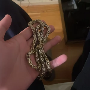 Guldplatterat kedja - Snyggt guldplatterat kedja med en vriden design som ger ett unikt utseende. Perfekt för att lägga till en touch av stil till din outfit.