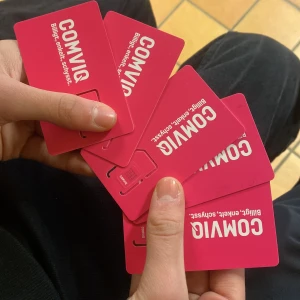 SIM-kort från Comviq - Flera SIM-kort från Comviq visas upp. Kortens framsida är rosa med Comviqs logotyp och texten 'Billigt, enkelt, smslöst'. Baksidan visar information om SIM-korten, inklusive streckkoder och chip. Perfekt för den som behöver ett nytt SIM-kort eller vill byta operatör.