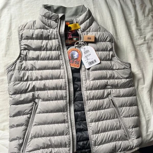 Parajumper väst  - Säljer en snygg grå dunväst från Parajumpers. Västen har en dragkedja framtill och en cool patch på bröstet. Perfekt för lager-på-lager under kyliga dagar. Skick 10/10 helt ny, sälj pgr av ingen användning. Kvitto finns, du kommer inte att hitta en bättre än den.☺️